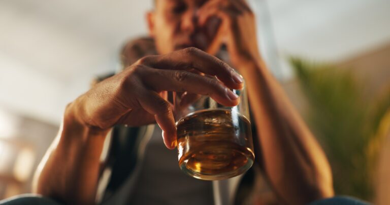 Alcoholic, stress and glass of whiskey with person in living room for substance abuse